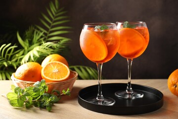 Fototapeta premium Refreshing spritzer cocktail with mint and oranges on wooden table
