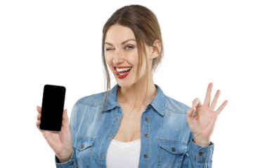 Beautiful excited girl winking, holding phone with blank screen and making OK gesture