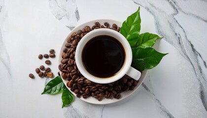 aromatic black coffee in a white cup surrounded by roasted coffee beans and fresh green leaves on marble