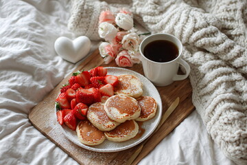 cozy Valentine's Day breakfast in bed with pancakes, strawberries, and coffee hearts