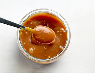 freshly cooked homemade caramel sauce in jar