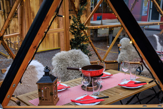 Cozy tables with fur throws in a Christmas igloo restaurant in Bern, Switzerland - Powered by Adobe