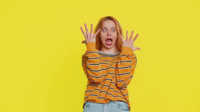 Amazed shocked excited Caucasian blonde woman in blouse touching head and showing head explosion, looking worried and shocked, professional burnout. Young adult girl isolated on yellow background