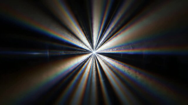 Abstract radial light streaks and rainbow colors exploding from a central point on a dark background
