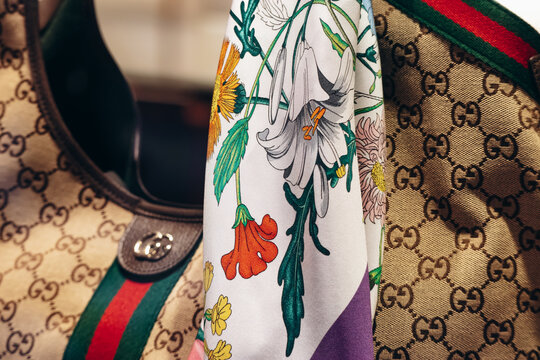 Nice, France &ndash; August 2, 2025: Gucci silk Flora scarf displayed with a Gucci monogram handbag in a luxury store window
