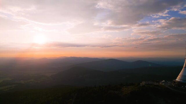 Watch as the sun sets over Jested Mountain and the hotel, casting a warm glow across the landscape. This aerial view showcases the beauty of Liberec and its iconic TV transmitter.
