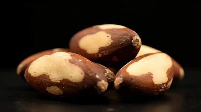 Close Up of a Pile of Shelled Brazil Nuts Slowly Rotating on a Black Background