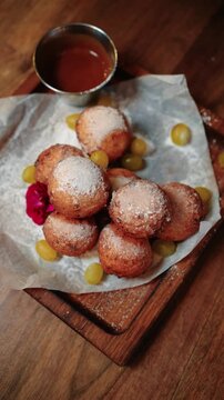 Close-up of freshly made mini ponchiki (small donuts) arranged on a plate, highlighting traditional sweet treats and festive desserts.
