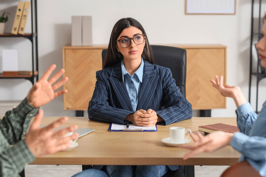 Female family mediator working with couple at table in office