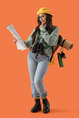 Thoughtful female guide with map on orange background