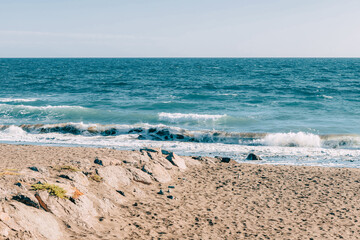 Empty sandy beach on Fuerteventura, Canary Islands, with gentle ocean waves and a wide horizon, minimalist coastal landscape evoking solitude, freedom, travel and winter escape