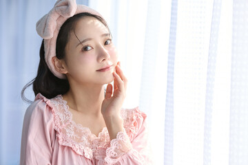 窓際に立つかわいい女性の美容ポートレート