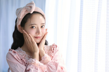 窓際に立つかわいい女性の美容ポートレート