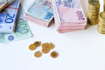 Traditional Turkish Gold coins with euro and Turkish Lira banknotes on white surface,financial concept