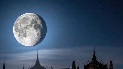 Full moon shines over ornate roof peaks, dark starry night sky with light cloud veil