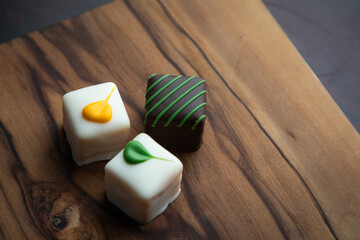 An elegant arrangement of artisan white chocolate squares, beautifully decorated and presented on a rustic wooden board. Perfect for gifts and celebrations.