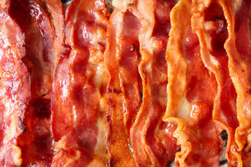 Texture of fried bacon rashers as background, closeup
