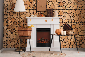 Obraz premium Stylish interior of living room with fireplace, coffee table, basket and lamp