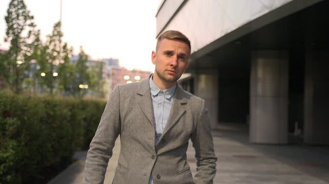Young man walking and taking off sunglasses in the city. Slow motion