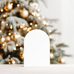 Arch-shaped card mockup with golden Christmas tree and soft lights in background
