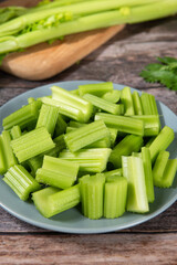 Fresh green cut celery on wooden table.