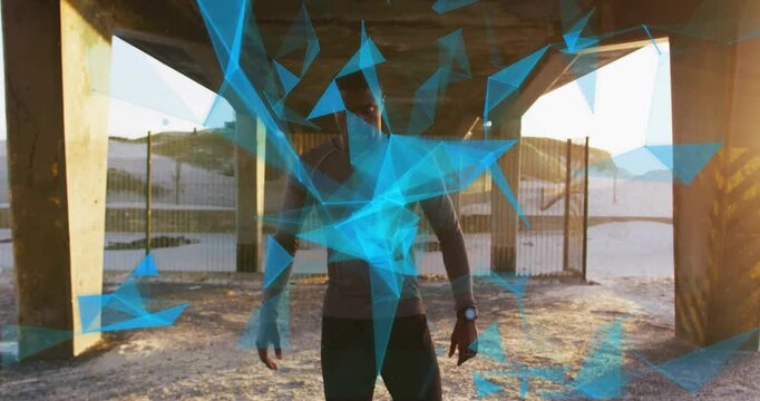 Man walking under overpass toward camera, starting tech particles circling chest, revealing watch