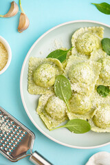 Plate of tasty ravioli with cheese on blue background, closeup