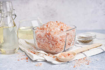 Glass bowl and spoon with Himalayan pink salt on white background