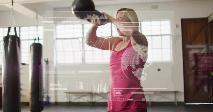 Woman lowering hips and driving kettlebell in gym, building strength while HUD charts tracking reps