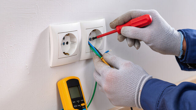 electrician fixing electrical outlet