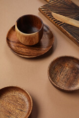 Different wooden tableware on brown background
