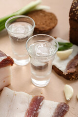 Shots with cold vodka on beige background