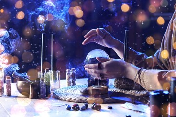 Fortune teller with crystal ball and magic attributes reading future at table