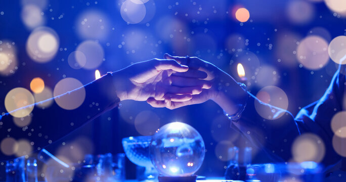 Fortune teller reading woman's palm at table