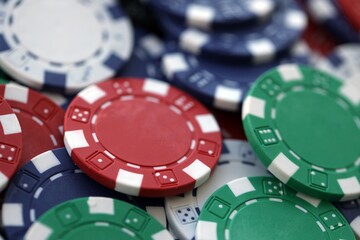 Close up of a group of casino chips on a green mat for poker or dice games indoors