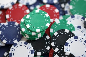 Close up of a group of casino chips on a green mat for poker or dice games indoors