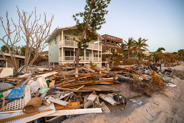 Piles of debris on street side in Florida. Hurricane aftermath cleanup. Garbage from severely damaged homes after storm surge. Consequences of natural disaster © bilanol