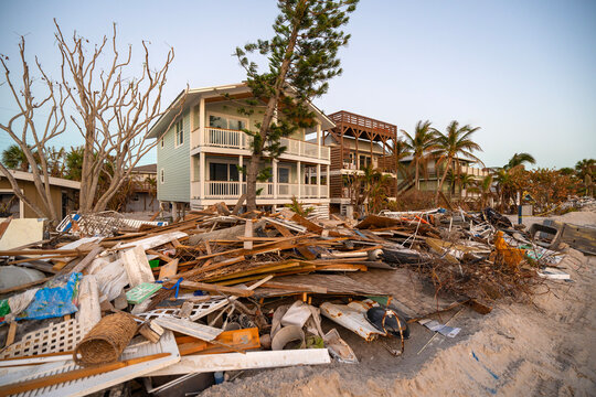 Piles of debris on street side in Florida. Hurricane aftermath cleanup. Garbage from severely damaged homes after storm surge. Consequences of natural disaster