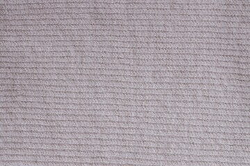 Texture of knitted pastel pink sweater, close-up texture of beige pink