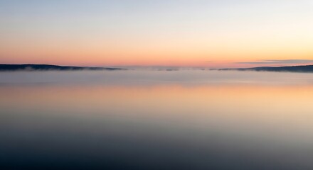 Fototapeta premium Serene Sunset Reflection on Calm Water with Distant Land.