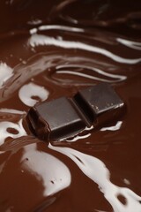 Tasty melted chocolate and piece as background, closeup