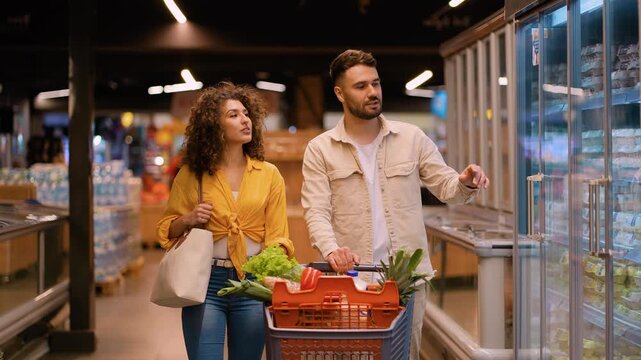Young couple shopping for groceries together in supermarket - Powered by Adobe
