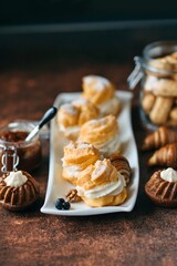 Sweet pastry cream puffs on white plate