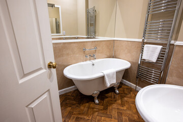 Interior European luxury hotel bathroom, fresh clean white cotton bath towel on metal heated towel...