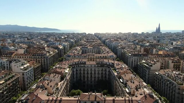 A stunning aerial perspective of Barcelona's urban symmetry with iconic architecture and the sea in the distance.
