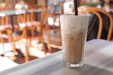 Enjoying iced coffee in a cafe with empty chairs
