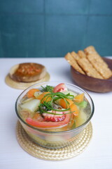 Clear soup with potatoe, carrot and tomatoe. Served in bowl on white background.
