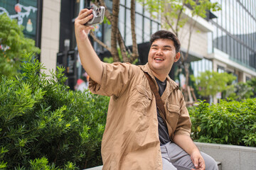 Two professional Asian adults posing for a selfie with shopping bags, symbolizing successful modern consumption and contemporary city lifestyle.