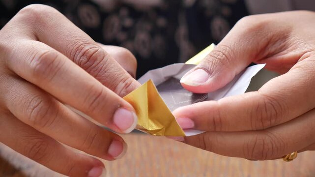Closeup of Hands unwrapping chocolate candy