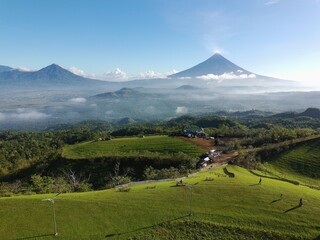 Fototapeta premium Mayon Volcano Panorama with a beatiful blue sky and sea of clouds view of mountain hills in Tigbao Green Hills Ligao Albay Philippines 